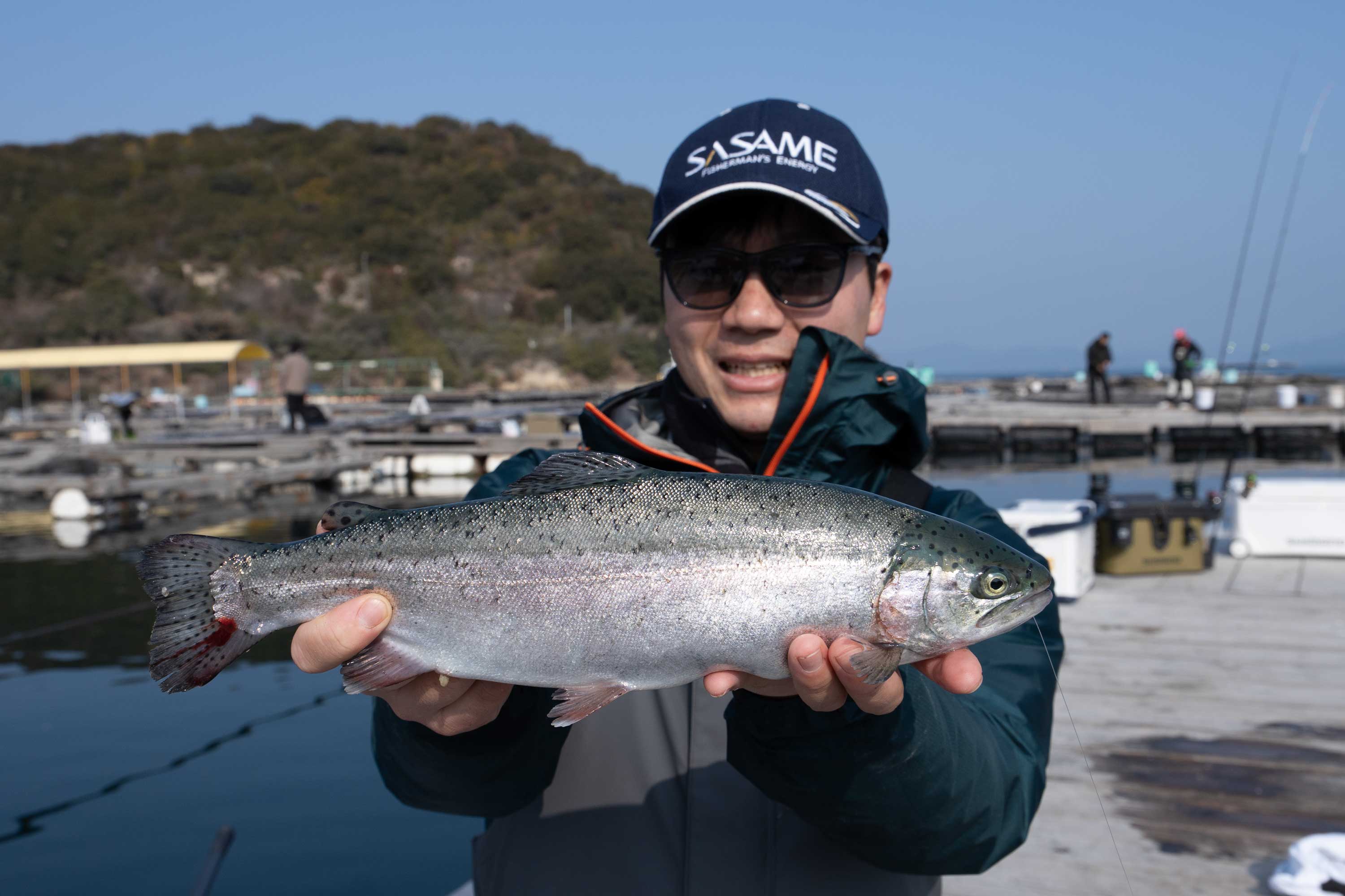 釣り上げた魚を持つ男性社員